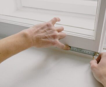 crop worker measuring window frame with ruler