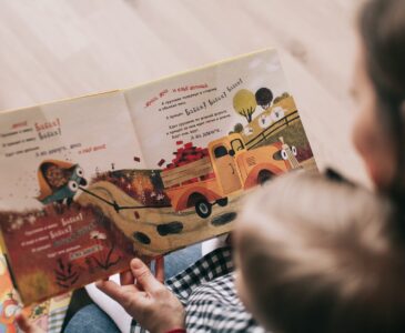 woman reading book to toddler