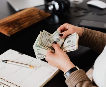 crop woman counting money at modern office table